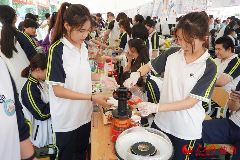 幾位北京經(jīng)濟(jì)管理學(xué)校學(xué)生在一起給顧客制作鮮榨西瓜汁 何淼/攝