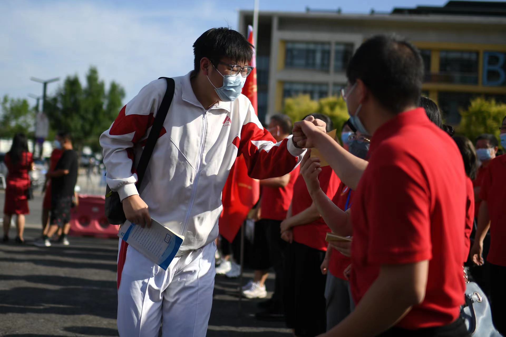 6月7日，在北京市人大附中通州校區(qū)考點(diǎn)，考生與送考老師擊拳加油。當(dāng)日，2022年北京市高考開考，4.8萬(wàn)余考生走入考場(chǎng)。人民網(wǎng)記者 翁奇羽攝