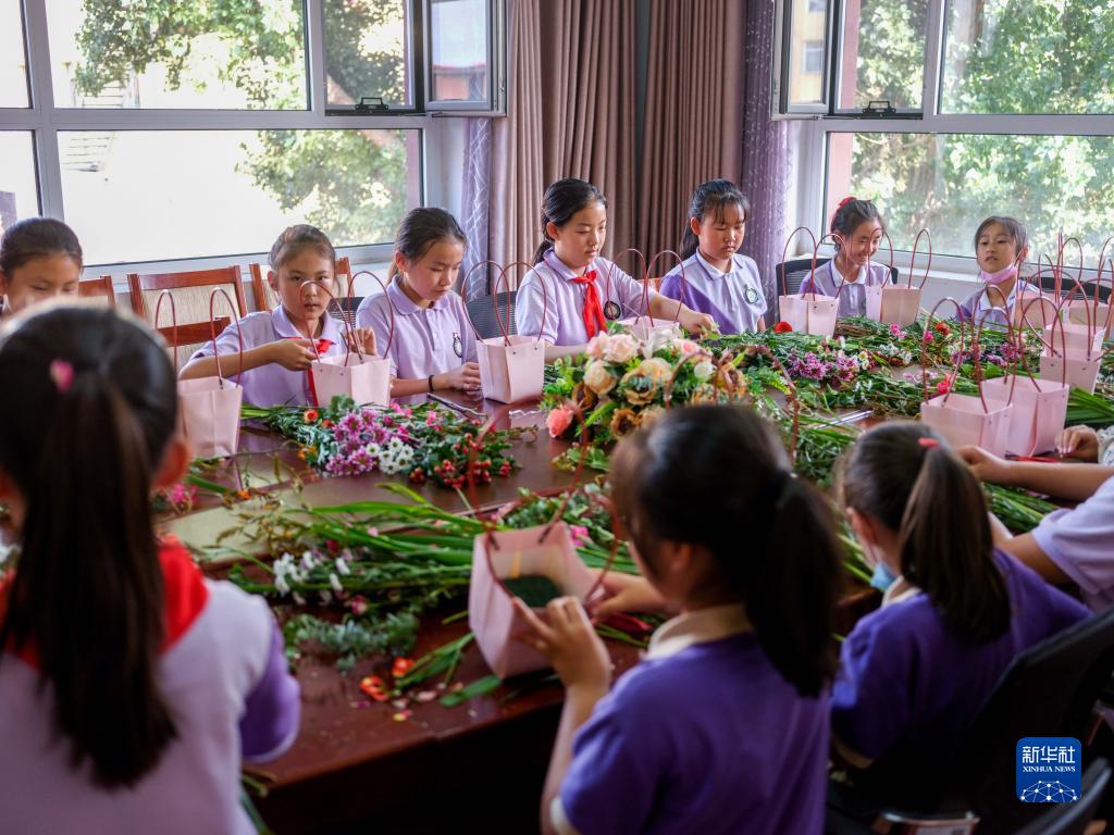 6月24日，在包頭市昆都侖區(qū)包鋼第十七小學，學生們利用課余時間學習插花。