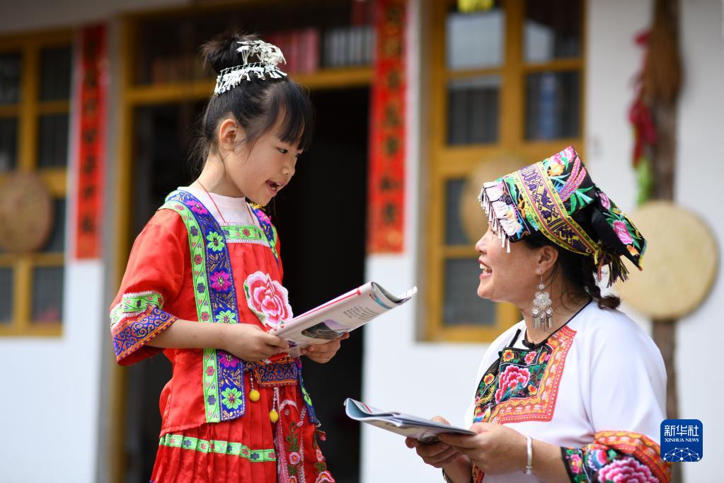 7月19日，湖南省邵陽(yáng)市城步苗族自治縣長(zhǎng)安營(yíng)鎮(zhèn)民族文化傳播服務(wù)中心，一名小朋友在向“六月六”山歌節(jié)市級(jí)傳承人陳巖花（右）學(xué)習(xí)唱山歌。新華社發(fā)（嚴(yán)欽龍攝）