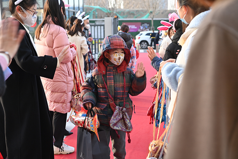 2月13日，昌平區(qū)北京十一未來城學校的老師們歡迎同學們回到校園，他們給每位學生都掛上一個福袋，希望把一年的福氣都送給學生們。昌平區(qū)北京十一未來城學校供圖